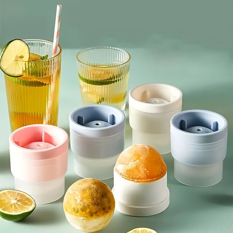 Drinks and fruit-filled ice spheres beside the silicone moulds